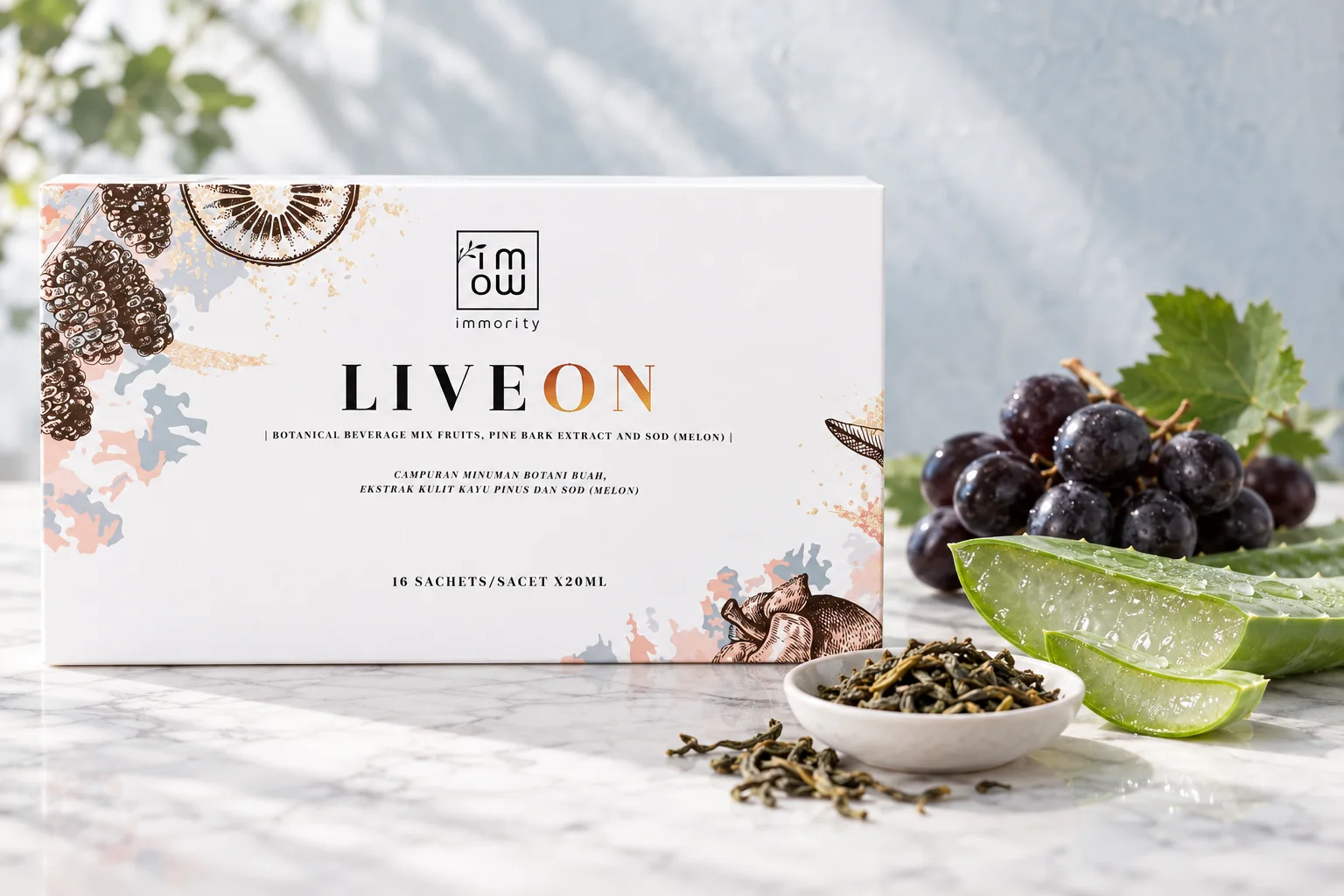 A LIVEON box beside a cut aloe vera leaf, black grapes and a dish of green tea leaves on grey marble