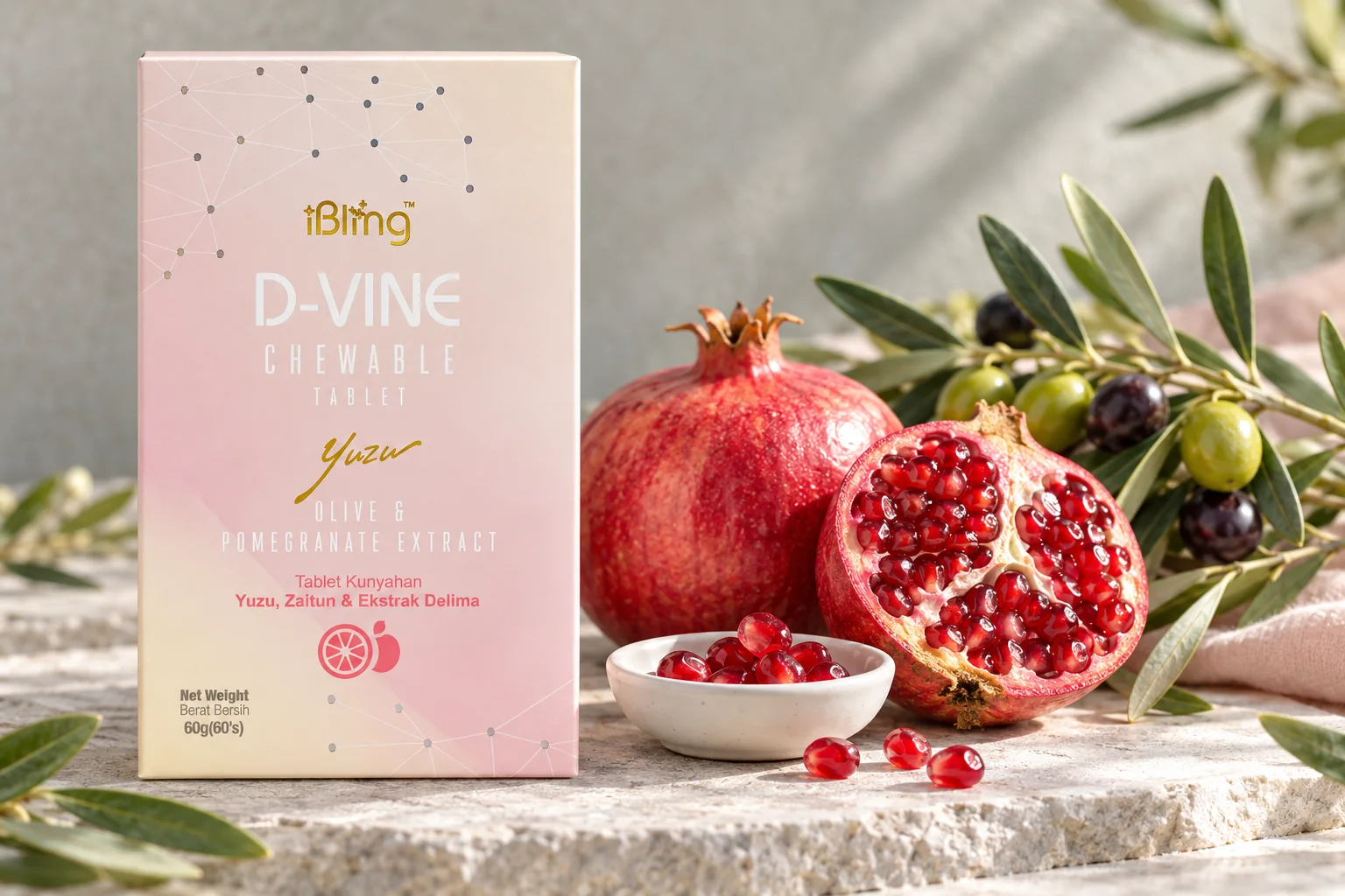 A D-VINE box beside a halved pomegranate, a dish of seeds and an olive branch on grey stone
