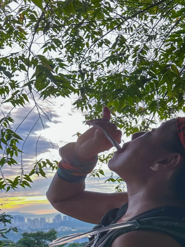 Hiker drinking a MOVEON sachet on a sunrise trail walk