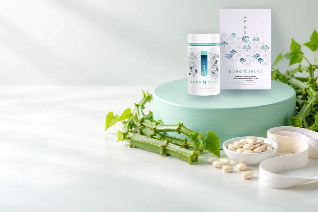 白色枱面上一個薄荷綠圓台，上面一樽 ZENSO Kuro SHUGA 同一盒；四周係四棱白粉藤嘅綠色莖、一碟白腎豆同一卷軟尺