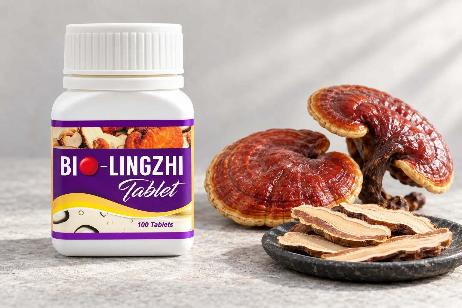 A BIO-LINGZHI Tablet bottle beside whole red reishi mushrooms on pale grey stone