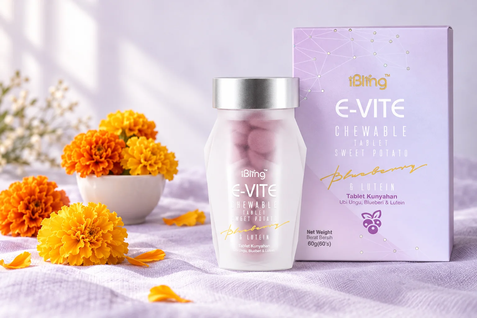 The E-VITE box and bottle beside orange and golden marigold flowers on lilac linen
