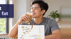 A fit man back from a morning walk drinking an iced Kuro Daitto Coffee shake, the Coffee box on the table and his gym bag on the floor. Coffee that helps burn fat.