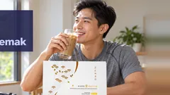 Seorang lelaki cergas yang baru pulang dari berjalan pagi minum bancuhan Kuro Daitto Kopi berais, kotak Kopi di atas meja dan beg gim di lantai. Kopi yang membantu membakar lemak.