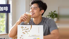 一位晨走回来的健康男士喝着冰 Kuro Daitto 咖啡，咖啡口味盒子放在桌上，运动包放在地上。帮助燃脂的咖啡。