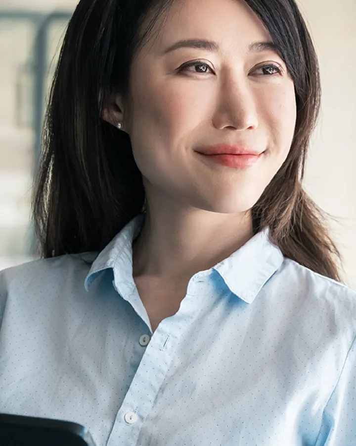 A smiling woman in her forties at her desk, from the Hwa Ae Rak campaign