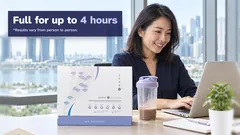 A woman smiling at her laptop in a Singapore office, Marina Bay behind her, her shaker and the Kuro Daitto box on the desk. Full for up to 4 hours. Results vary from person to person.