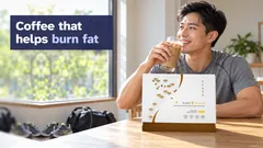 A man back from a morning walk drinking an iced Kuro Daitto Coffee shake, the Coffee box on the table and his gym bag on the floor. Coffee that helps burn fat.